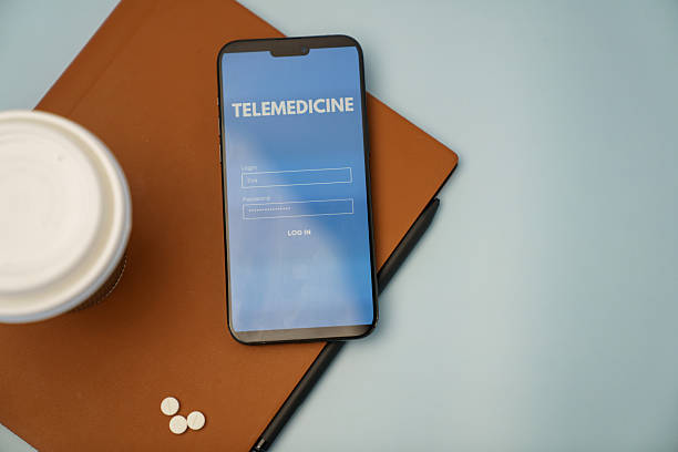 istock Smartphone Displaying Telemedicine Login Screen with Pills and Notebook on Desk 2218837113