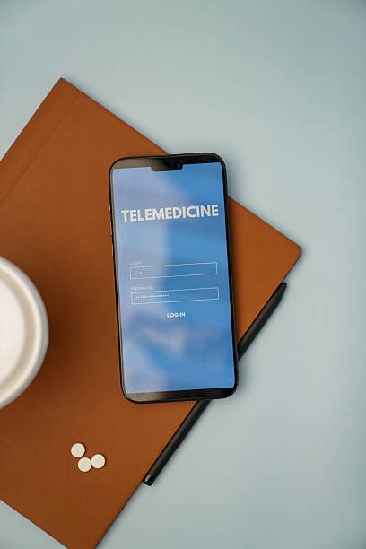istock Smartphone Displaying Telemedicine Login Screen with Pills and Notebook on Desk 2218837141