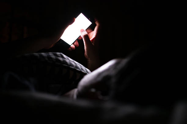 istock Image of a man looking at his smartphone in bed at night 2218839565