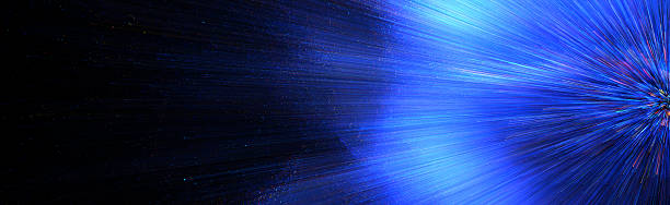 istock Abstract background of bright blue light rays and scattered particles bursting outwards from the right on a dark backdrop 2218841961