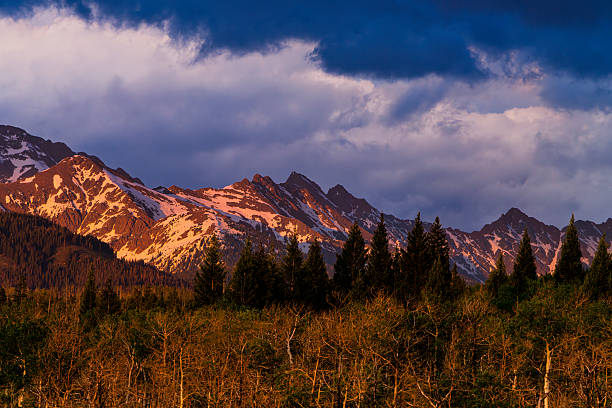 Snowcapped Peaks of the Gore Range in Spring with Dramatic Alpenglow Light - Vivid views of the Eagles Nest Wilderness Area in Colorado near Vail with warm sunset light illuminating the high peaks.