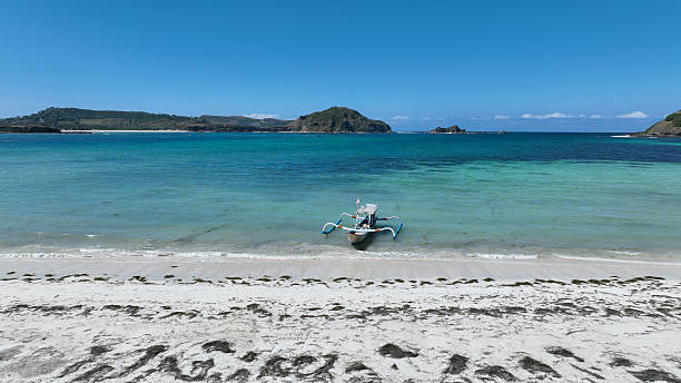 istock A traditional boat floats on crystal clear turquoise water, framed by white sand and distant green islands beneath the endless blue sky 2218842923