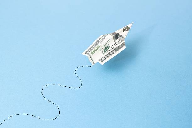 istock flying dollar airplane bill and its path on blue background 2218850639
