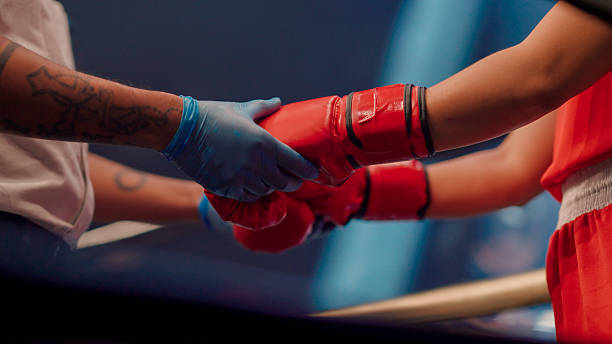 A close-up view of an Asian boxing referee checking the gloves worn by a contestant before the match started to ensure a fair fight.