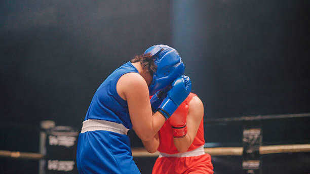 istock Young female boxers throwing punches at each other while competing in a boxing ring. 2218854493
