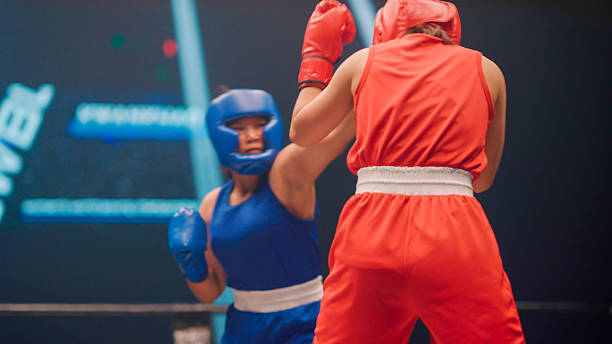 istock Two young female boxers punching and blocking each other during a fighting match in a stadium. 2218854616