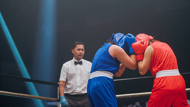 istock Two young female boxers punching and blocking each other during a fighting match in a stadium. 2218854855
