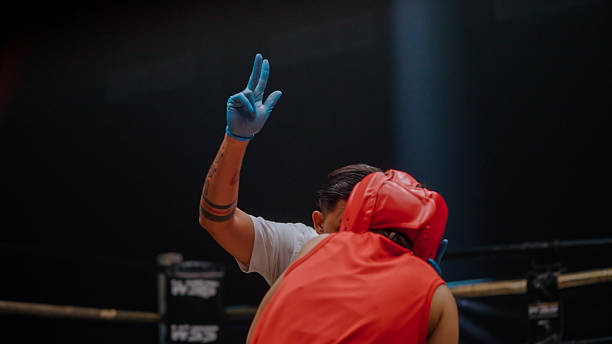 istock Young Asian referee declaring the match ending as he counted to ten for the knocked-down boxer. 2218854882