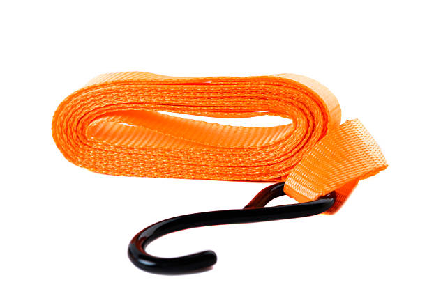 istock Isolated image of a coiled orange tie-down strap with black hook and metal ratchet. Clean product image for online sales or catalog. 2218856507