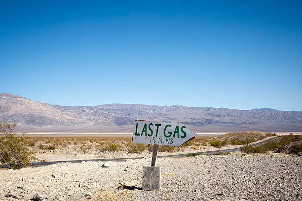 Rocky, barren desert landscape with a hand-lettered sign that says \