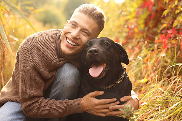 istock Smiling man hugging cute dog outdoors on autumn day 2218859807