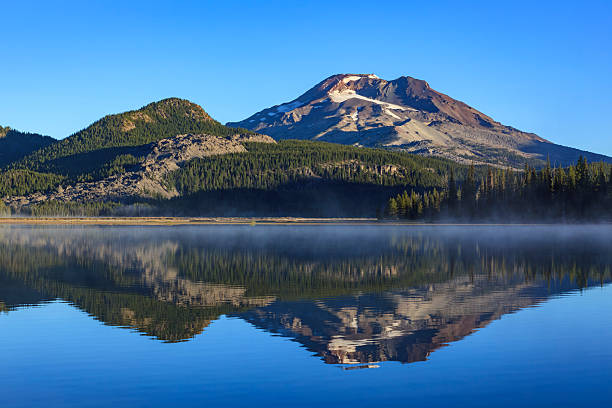 View of South Sister, a prominent stratovolcano in the Cascade Range, reflected in the calm waters of Sparks Lake near Bend, Oregon.