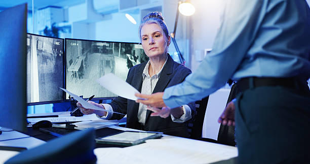istock Woman, documents and security surveillance with computer for suspect at protection agency. Female person, paperwork and manager with information, observation report or safety protocol at control room 2218866276