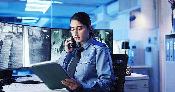 istock Phone call, security guard and woman with tablet, display or cctv screen in night shift for safety or video surveillance. Camera, footage or person with communication in control room for protection 2218866306