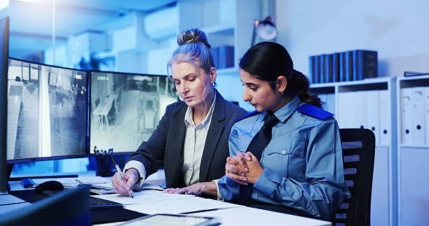 istock Woman, writing and security surveillance with documents for suspect at protection agency. Female person, paperwork and monitor with information for private investigation, report or safety measure 2218866307