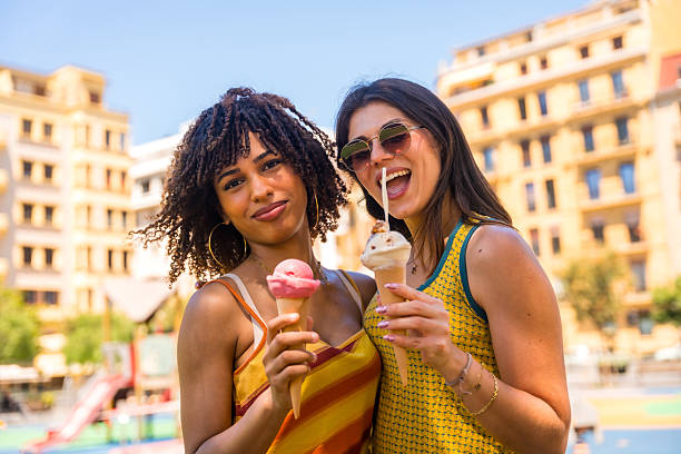istock Two happy young women eating ice cream outdoors in summer 2218870174