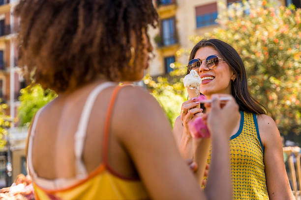 istock Two young women eating ice cream outdoors in summer 2218870185