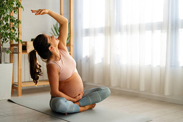 istock Relaxed pregnant woman doing breathing exercises while sitting on an exercise mat at home. 2218872822