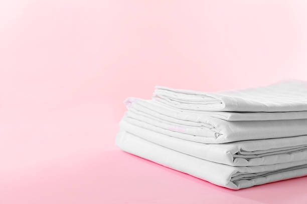 istock Stacked clean bed linens on pink background, space for text 2218874286