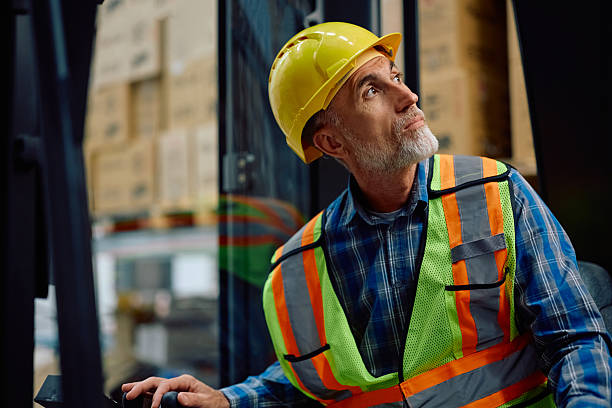 istock Senior worker driving forklift at distribution warehouse. 2218876983