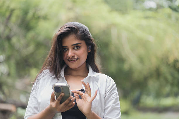 istock Smiling Young Woman Using Smartphone in Nature 2218877526