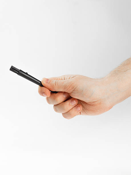 istock A persons hand is firmly holding onto a small black object 2218879797