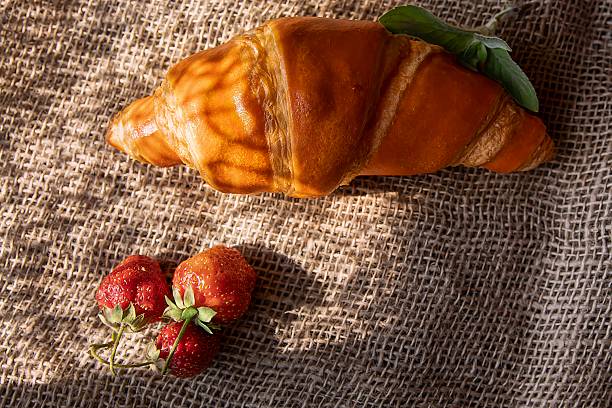 Cozy Morning Breakfast with Croissant, Strawberries and Mint on Burlap
