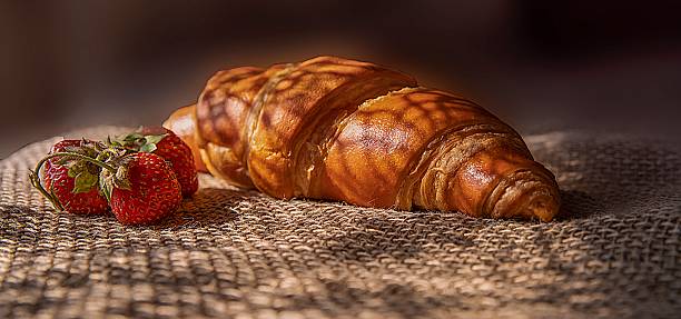 istock Fresh Croissant with Strawberries and Mint on Rustic Burlap Background 2218880146