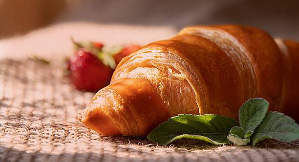 istock Cozy Morning Breakfast with Croissant, Strawberries and Mint on Burlap 2218880165