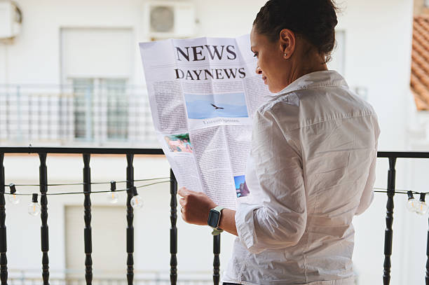 istock Woman Reading a Newspaper on a Balcony During Daytime 2218880659