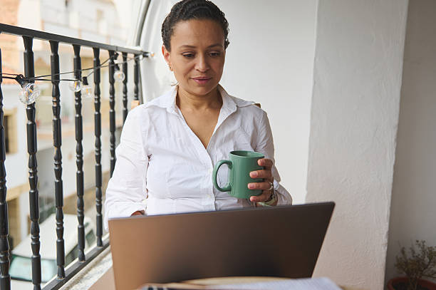 istock Woman Enjoying Coffee While Working from Home on Balcony 2218880667