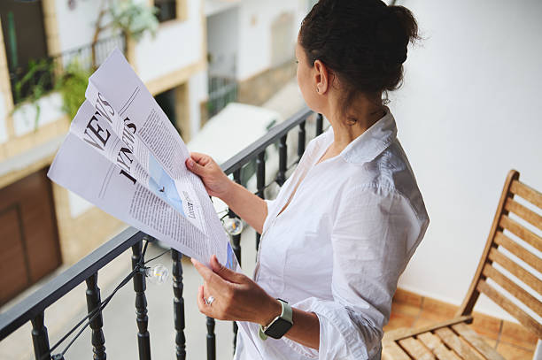 istock Woman on a Balcony Reading a Newspaper in a Casual Setting 2218880871