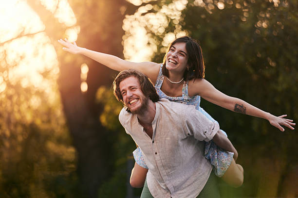 istock Cheerful couple piggybacking during springtime in nature at sunset. 2218881682