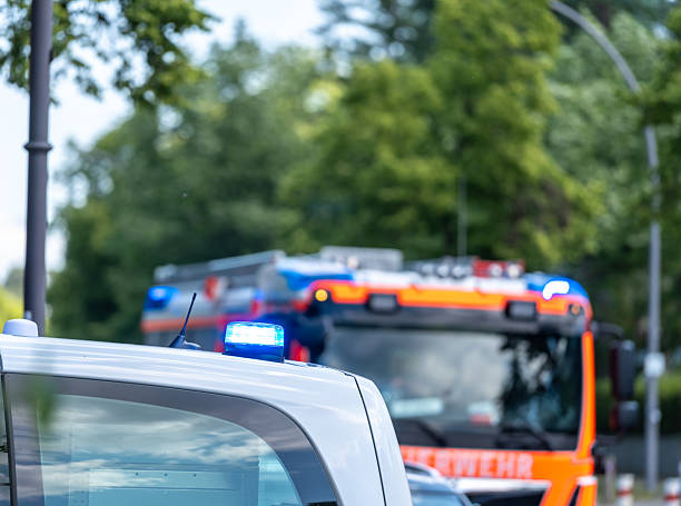 Germany, Berlin, Zehlendorf, June 03, 2025 - Police car with blue flash lights in front of a fire engine