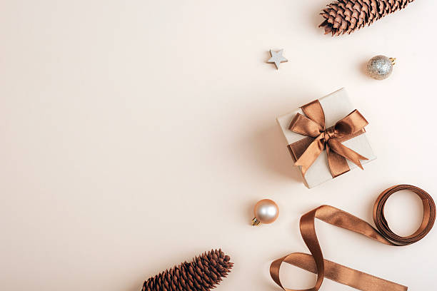 istock Flat lay with gift box, pine cones and christmas ornaments on soft beige background. Top view, copy space 2218884370