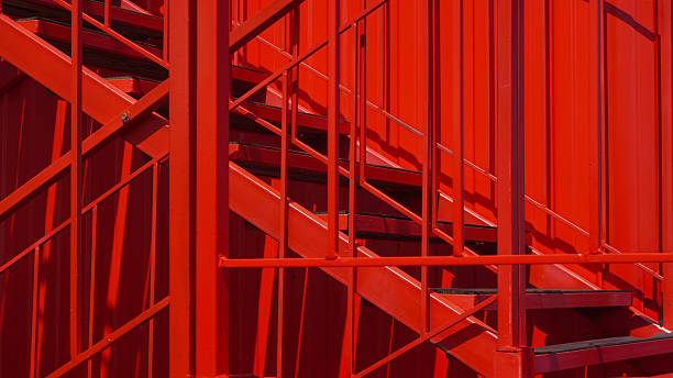 istock Red steel fire escape stairs in city environment with clear structural lines 2218884817