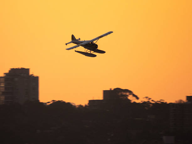 A Sydney Seaplanes De Havilland Canada DHC-2 Beaver seaplane, registration VH-NXF, descending as she comes into land at Rose Bay on Sydney Harbour. This image was taken from Dudley Page Reserve, Dover Heights on a windy, cold and sunny afternoon at sunset on 5 June 2025.