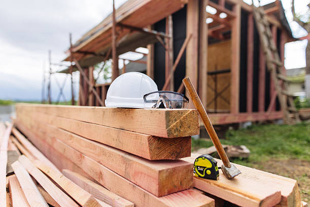 The work tools on the stacked lumber at the frame house construction site