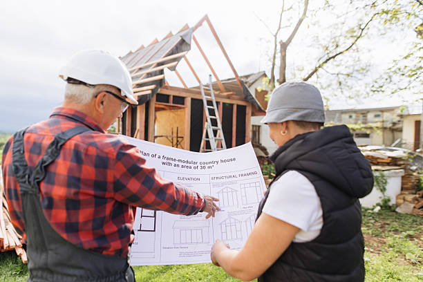 istock Experienced Builder Discussing Blueprints with Female Client at Wood Frame Construction Site 2218886505