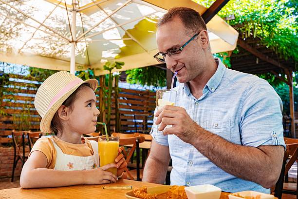 istock Father and daughter enjoying a refreshing drink at a restaurant 2218886685