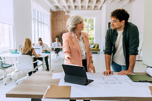 istock Colleagues standing and discussing architectural blueprints 2218888027