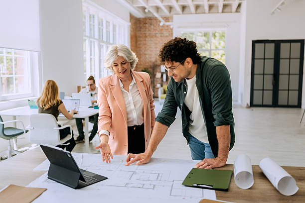 istock Colleagues standing and discussing architectural blueprints 2218888185