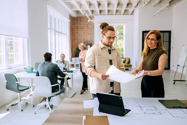 istock Colleagues standing and discussing architectural blueprints 2218888257