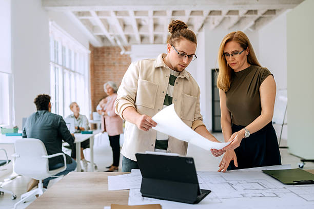 istock Colleagues standing and discussing architectural blueprints 2218888258