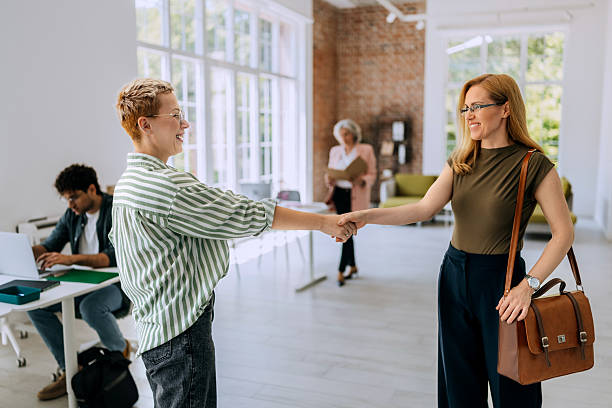 istock Two businesswomen shaking hands at modern office 2218888403