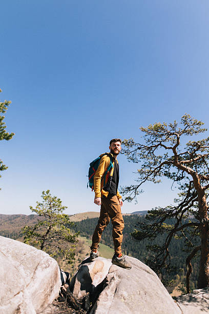 istock Brave man hiker standing on the rock in nature 2218890986