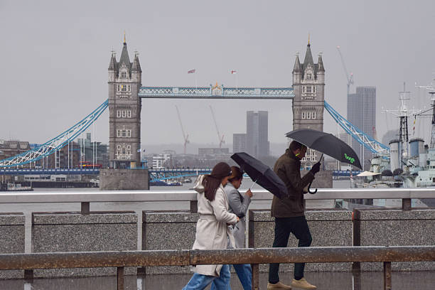 London, UK - May 4, 2011: man playing bagpipe on Westminster Bridge in London while people walk by. Photo taken with a tilt shift lens.