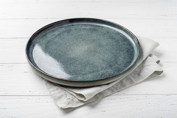 istock An empty grey textured plate on a white wooden table 2218895448