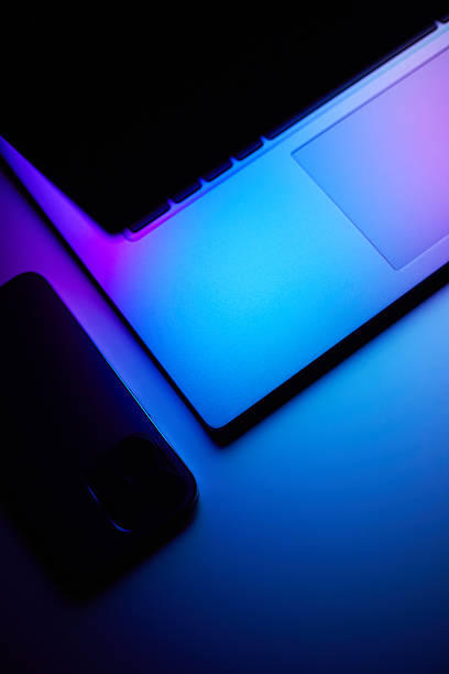 istock Laptop with smartphone. Neon dark light. 2218895843