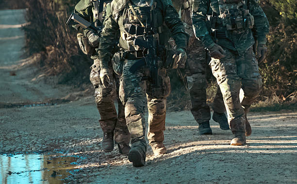 istock Soldiers walking on a dirt road during a military operation 2218900656